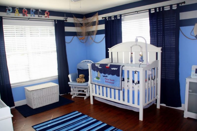 White baby crib in a room with blue curtains