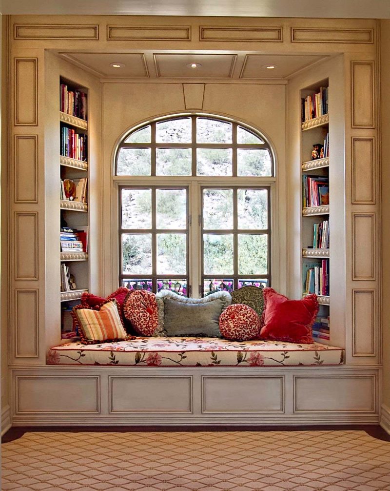 Un petit canapé pour lire des livres dans l'ouverture de la fenêtre