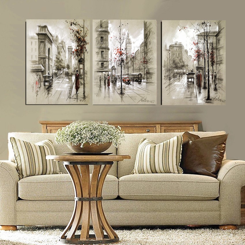 Tre dipinti sul divano nel soggiorno