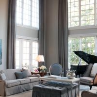 Black piano in the living room with large windows