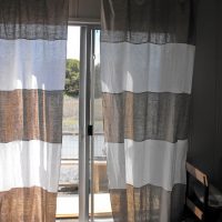 Finestra della camera da letto con tende grigie e bianche