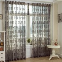 Gray curtains made of transparent fabric on the living room window
