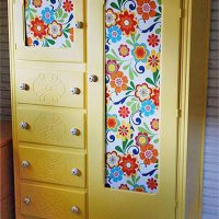 Yellow cupboard with paper wallpaper
