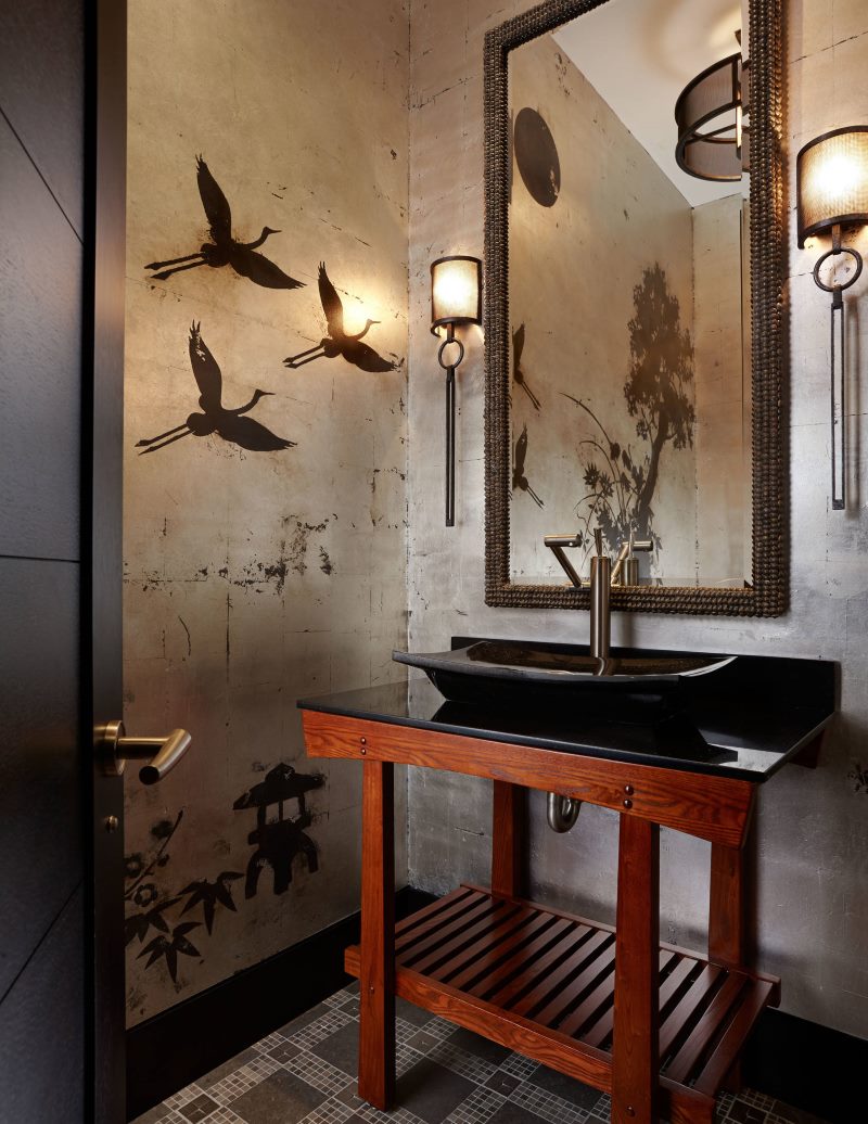 Black sink on a wooden stand in an oriental style bathroom