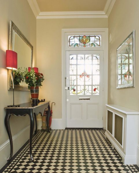 The entrance hall in a classic style will be cozy with dark tiles.