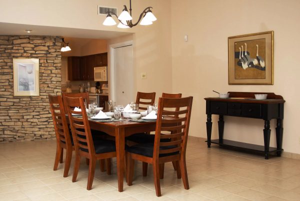 Les chaises en bois créent un sentiment de confort et d'harmonie, ce qui met les invités à la disposition des propriétaires de la maison.